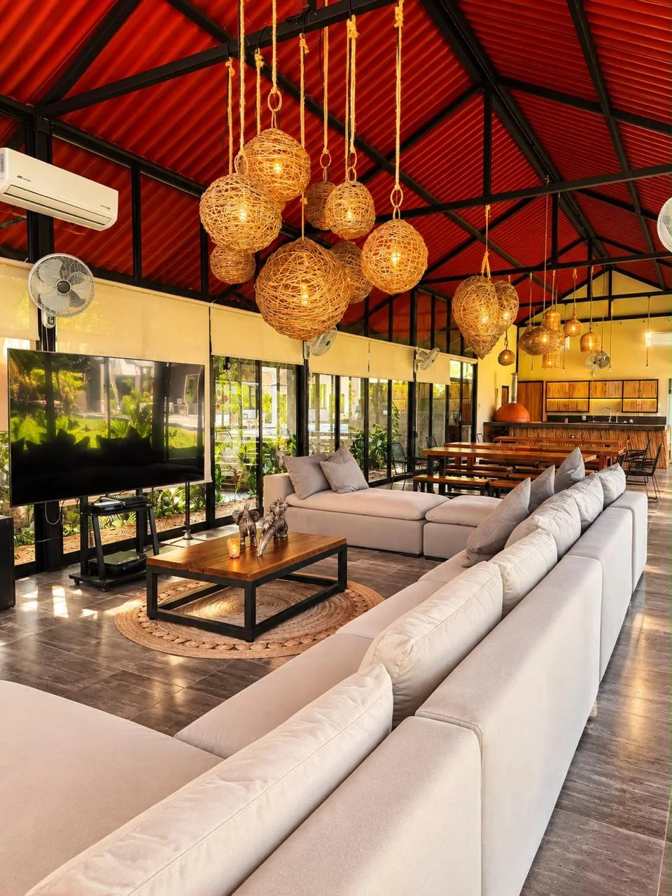 Interior de la zona BBQ con lámparas de mimbre y sala