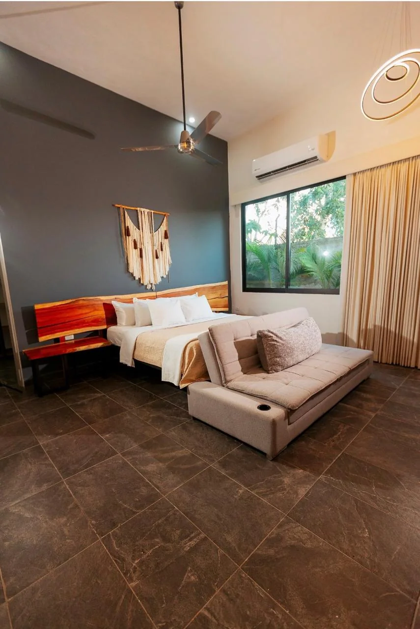 Habitación principal con cama King, sofá cama y ventana al jardín